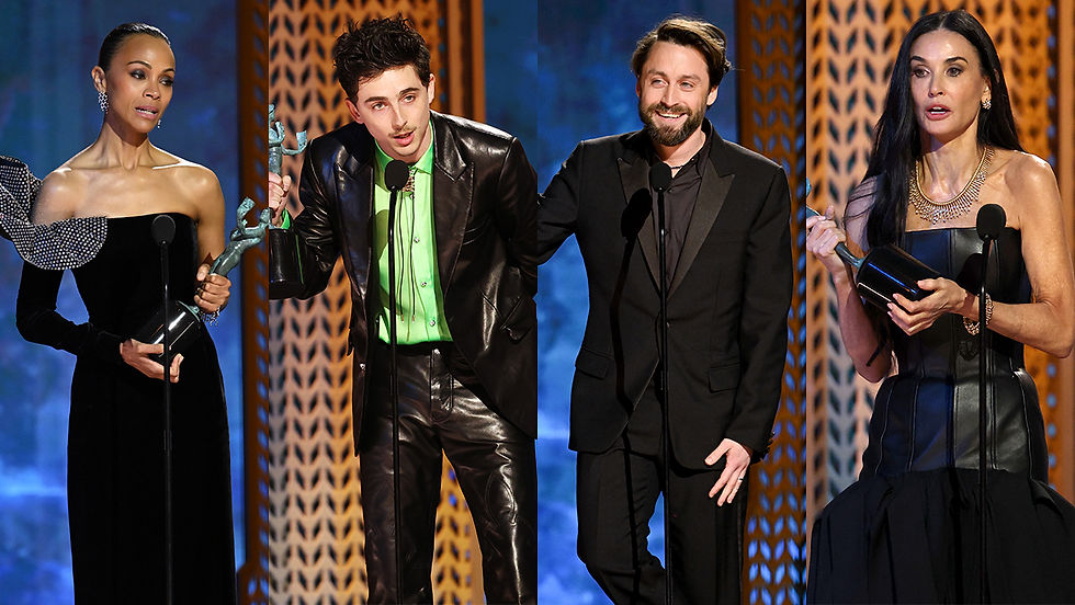 Four people on stage holding awards, dressed formally. Background features a blue and patterned design, with a celebratory mood.
