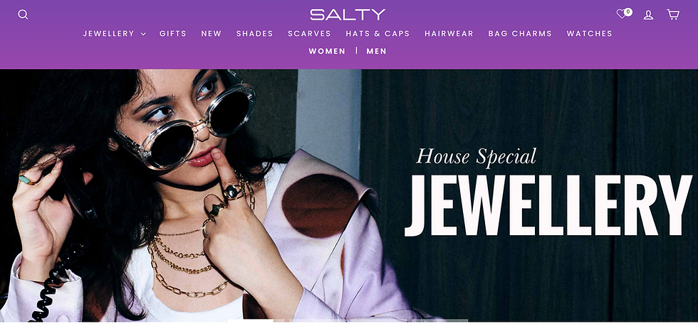 Woman with sunglasses and layered necklaces, holding a phone, finger on lips. Text: "House Special Jewellery." Purple header with menu.