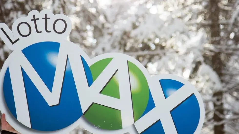 Sign with "Lotto MAX" in bold colors against snowy trees, held by a hand. Blue and green circles; bright and crisp winter scene.