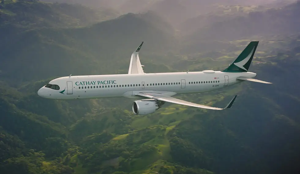 A Cathay Pacific plane flies over lush green mountains, showcasing its sleek, white body and green tail logo. The mood is serene and majestic.