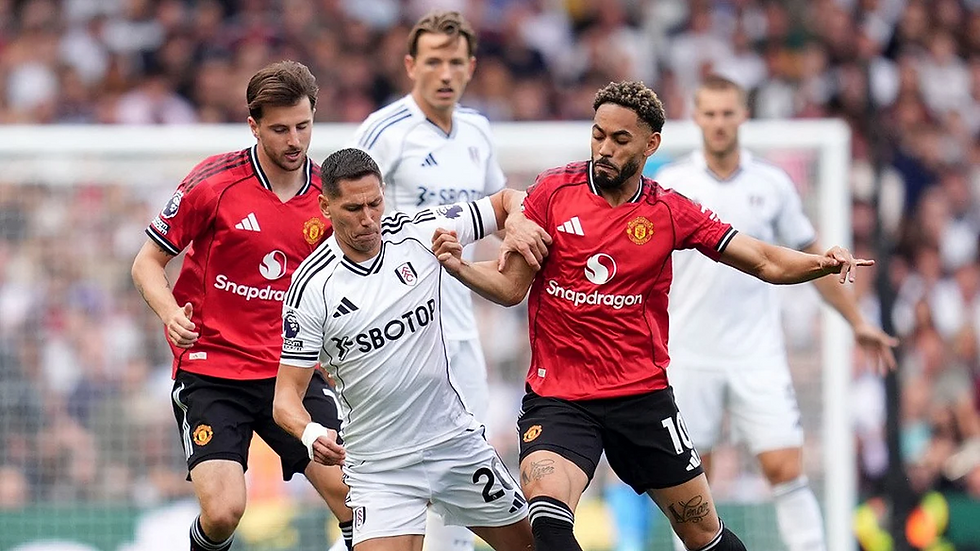 Soccer match: Players in red and white jerseys compete for the ball. Text on jerseys: "Snapdragon" and "SBOTOP". Intense action.