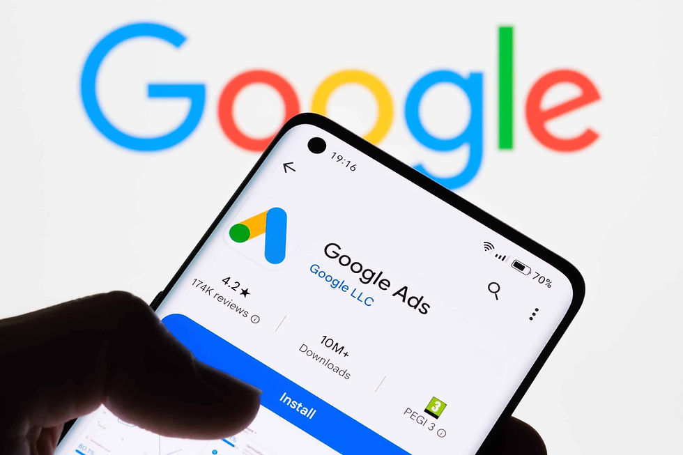 Hand holding a phone displaying the Google Ads app page with 4.2 stars and 10M+ downloads. Google logo is visible in the background.