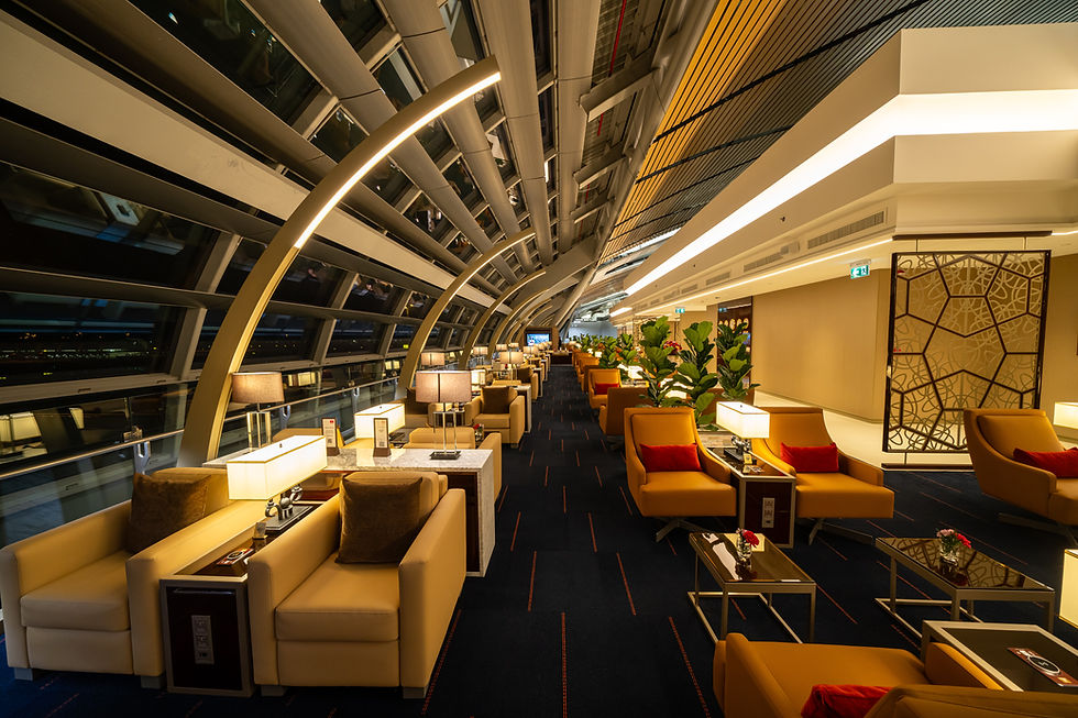 Luxurious airport lounge with modern architecture, beige seating, red pillows, warm lighting, and plants. Calm, elegant atmosphere.