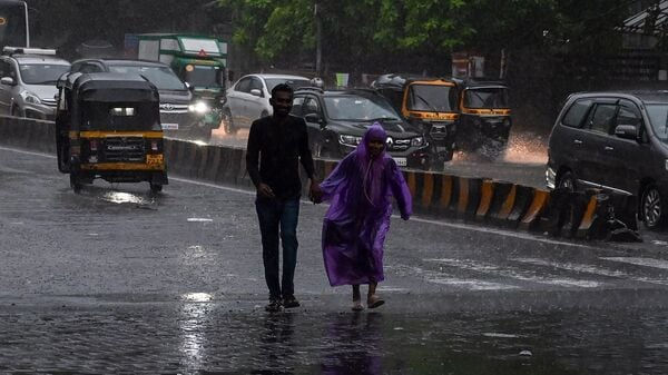 A couple walks hand in hand in heavy rain on a city street. The man wears black; the woman dons a purple raincoat. Autos and cars drive by.