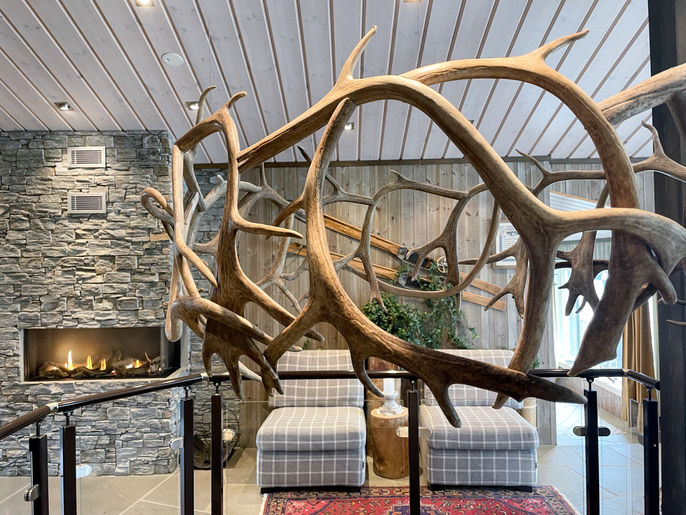 Dekorasjon av gevir hengt opp i fjellstue / fjellhotell. Krans lagd av reinsdyrgevir