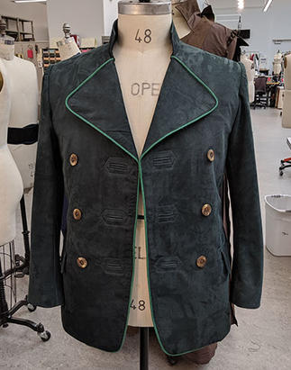 Hunter Jacket Front for San Francisco Opera's Hansel and Gretel. A dark green leather jacket with light green piping around the lapels and down center front, bound buttonholes and wooden buttons. 