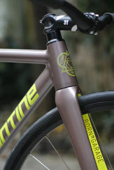 Detalle de bicicleta color bronce, logotipo 'ADORNED'