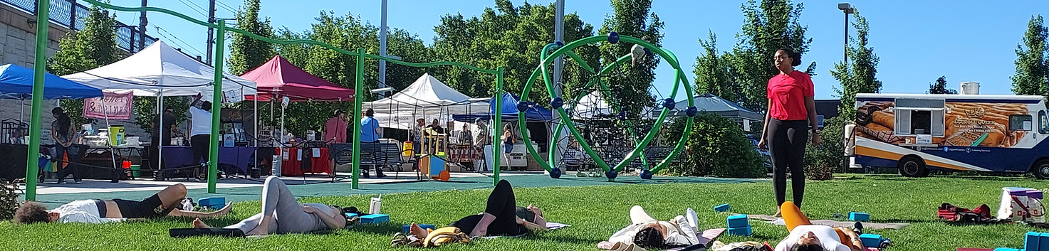 Marketgoers lounging on the grass after yoga