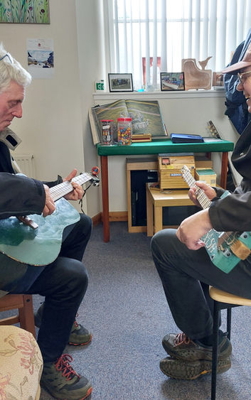 Members of the music group practicing on guitars