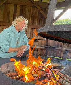 En man sitter vid en öppen eld