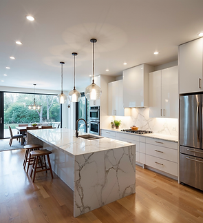 A modern kitchen with a large marble island, pendant lighting, stainless steel appliances, and an open layout leading to a dining area with large windows.