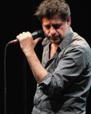 On y voit deux acteurs, un homme et une femme, profondément impliqués dans leur performance, les microphones servant d'accessoires principaux. Ils semblent être en plein cœur d'une scène dramatique et chargée d'émotion.