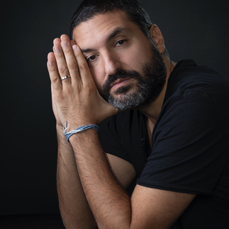 Portrait d'Ibrahim Maalouf, se reposant le visage contre sa main, affichant un regard pensif.