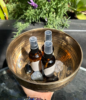 Holistic healing tools including crystals and a singing bowl, used for kinesiology and energy healing in a calm home-clinic space.