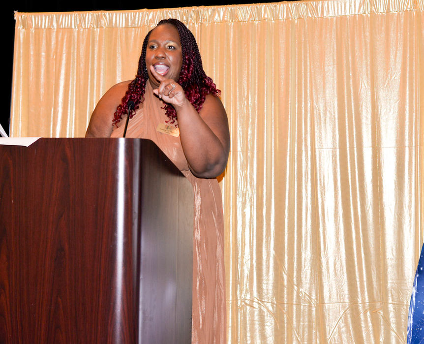 Jessica giving a speech at a podium at the FAWL Gala