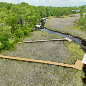 Aerial view of wooden walkways through a coastal marsh.