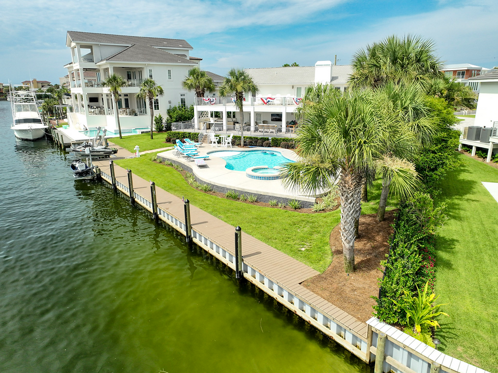 Waterfront home with private dock, swimming pool, and palm trees