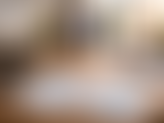 Financial report sheets with charts and graphs on a wooden office desk, with calculator and blurred business team in background representing integrated payroll, HR and CFO services