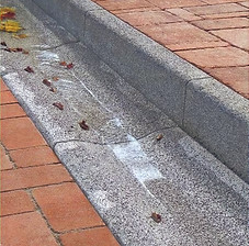 Kerbstone & Saucer drain on road with pavers