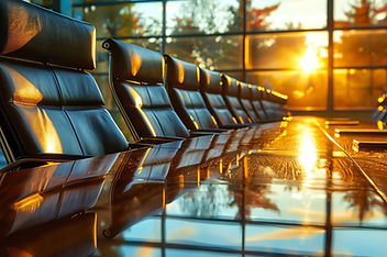 Modern corporate boardroom with executive chairs around a conference table at sunset.