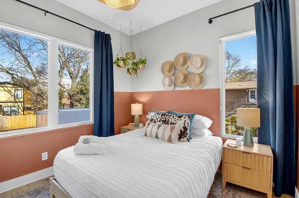 Bright bedroom with terracotta accent wall and natural wood furniture at Nashville farmers market vendor property