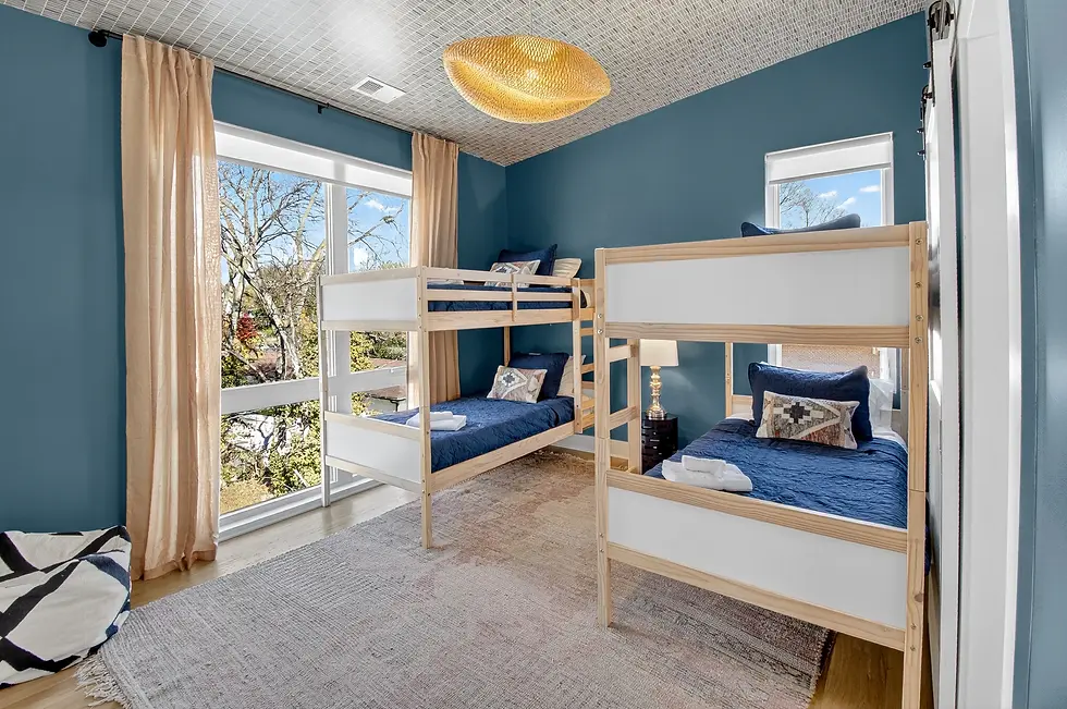 Modern shared bedroom with teal walls, natural wood bunk beds, and navy bedding at The Herman Haven Nashville vacation rental