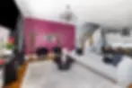 Modern living room with magenta accent wall and sectional sofa at Nashville group stay property