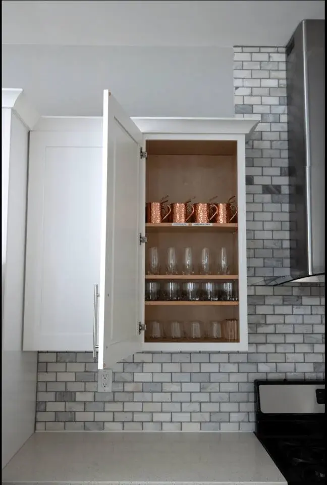 Modern kitchen shelving with copper mugs and subway tile backsplash at Nashville vacation rental