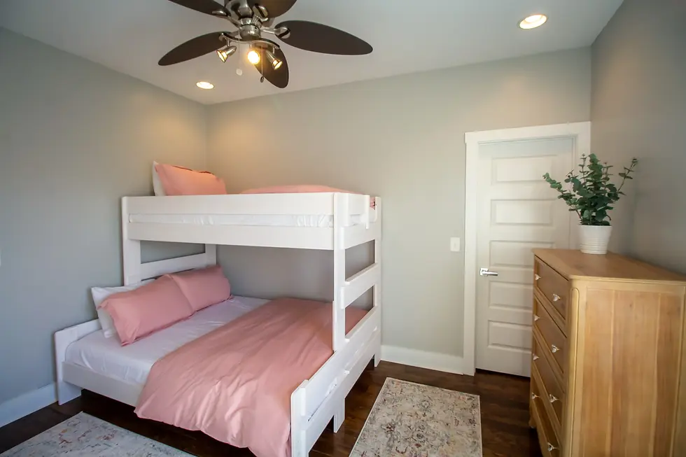 Children's bedroom in Nashville Tennessee vacation rental with white bunk bed, pink bedding, and rustic farmhouse style