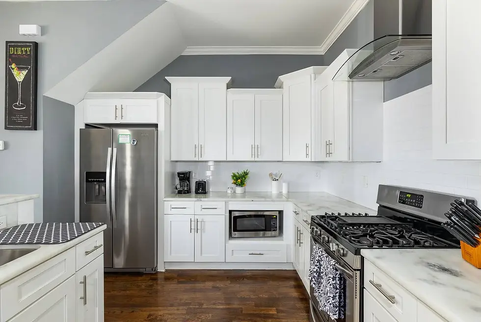 Fully stocked modern kitchen with white cabinetry, stainless steel appliances, and marble countertops at Nashville