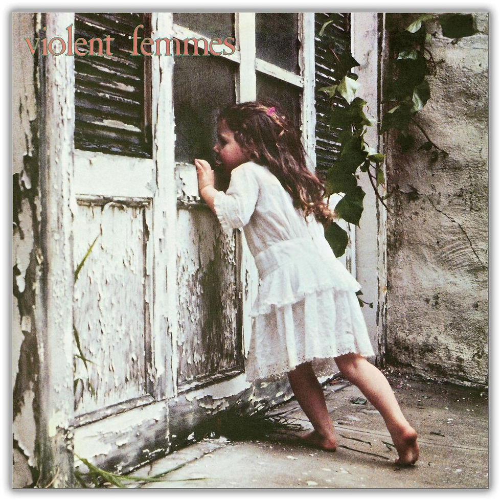 Album cover for the Violent Femmes' self-titled debut album featuring a barefoot young girl in a white dress peering through the glass of a weathered wooden screen door on an old house. The image has a rustic, mysterious feel, with the band's name displayed in the upper-left corner.