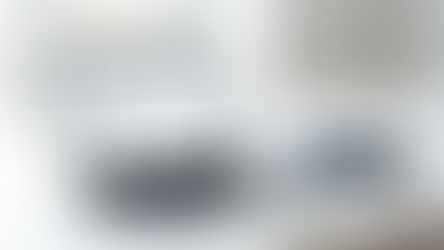 Modern executive dashboard on a MacBook displaying KPI metrics and performance charts, with a leather notebook and fountain pen on a minimalist desk