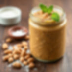 Salted peanut paste in jar with peanuts