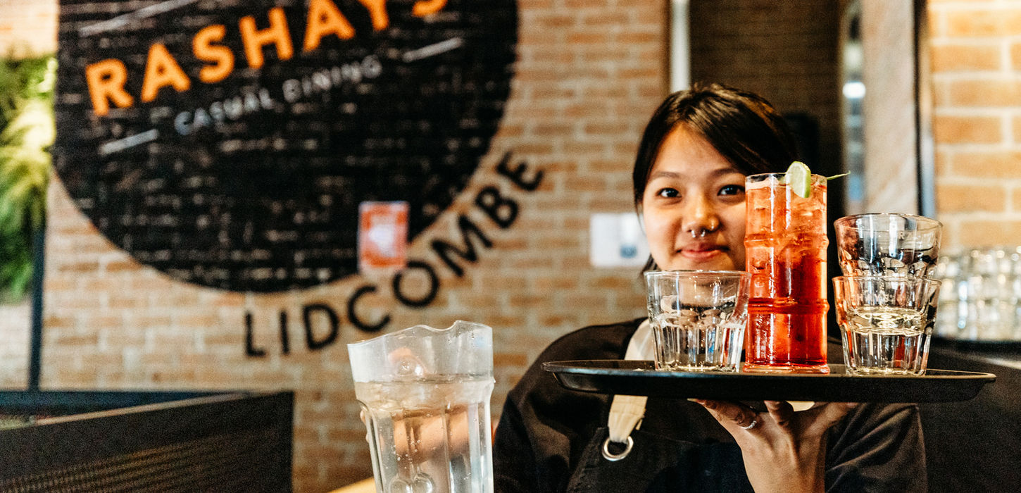 lidcombe shopping centre, lady serving drinks, snacks, burger and fries on plate