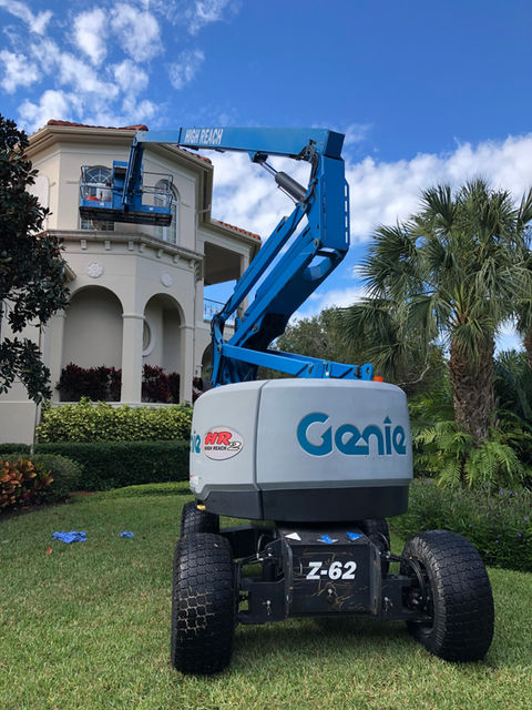 cleaning a high window with a boom lift