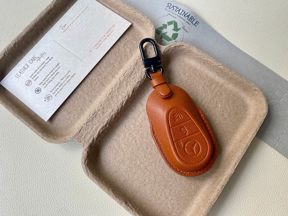 Vật phẩm màu nâu cam có móc cài trong hộp bao bì tái chế.