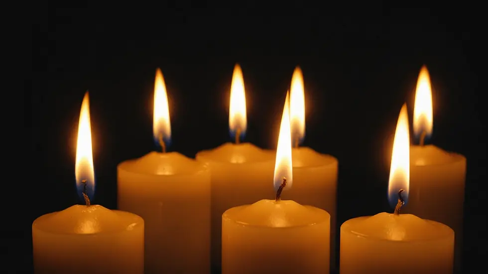 Close-up view of candle flame flickering in the dark