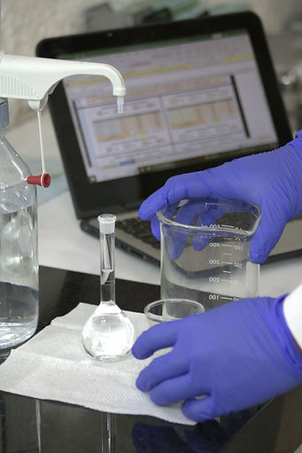 Händer i blå handskar håller en bägare och kolv, labb bakgrund, data.