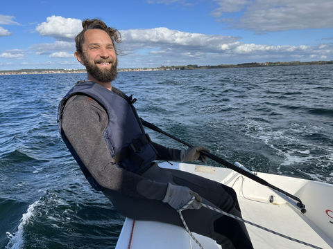 Glad seglare i segelbåt på havet