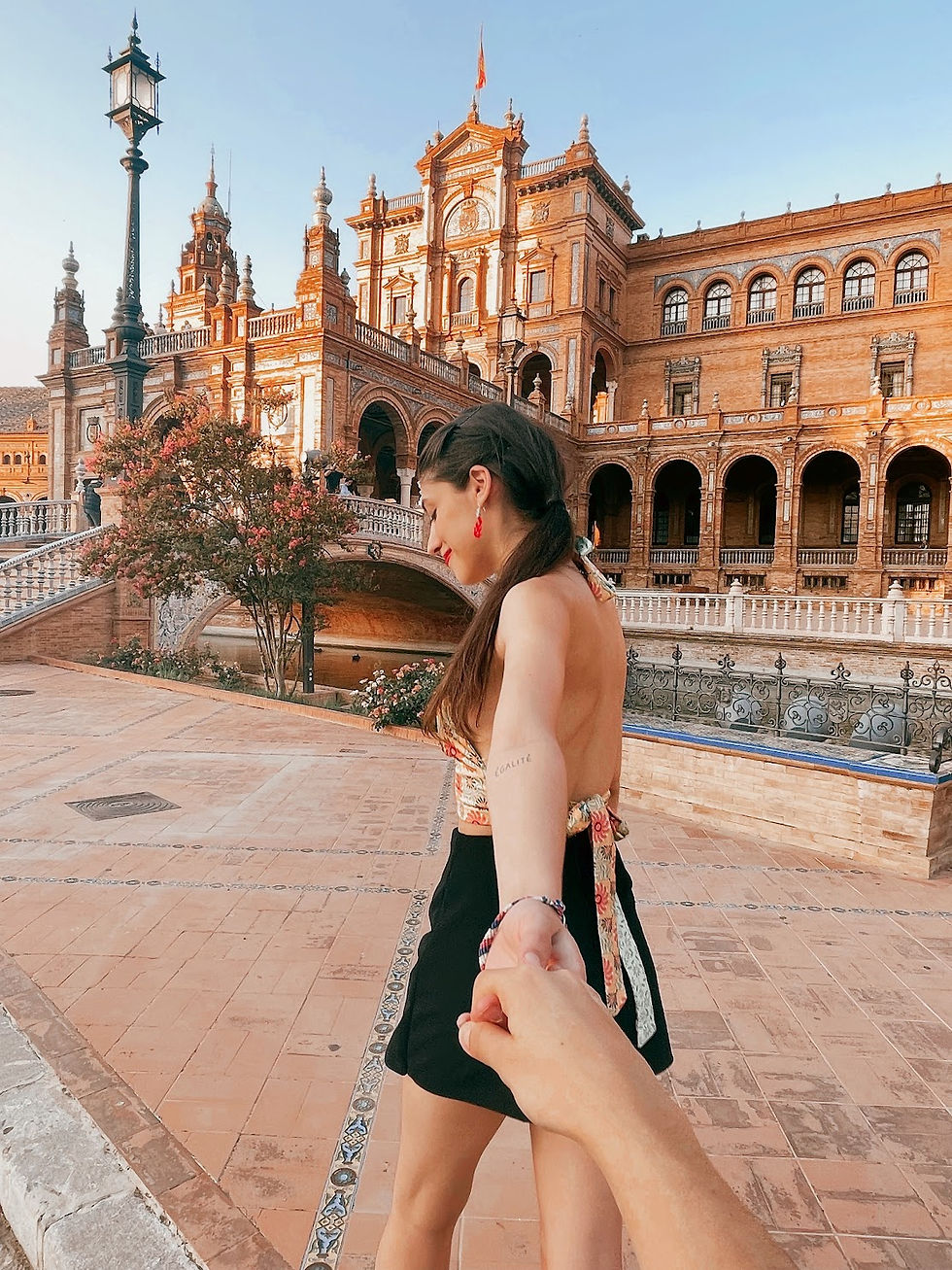 pov de mujer joven en la plaza de españa en sevilla de la mano con su novio