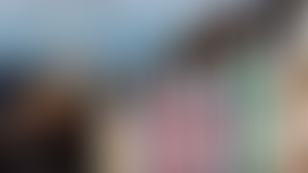 vista panoramica de brighton con casas en fila de colores rosa verde y azul y una rueda de la fortuna en el fondo delante del mar en inglaterra