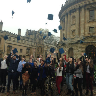 grupo de estudiantes graduados tirando su gorro de graduacion al aire frente a la liberia de la universidad de oxford en inglaterra reino unido