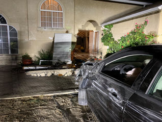 Car plows through house, 1 arrested