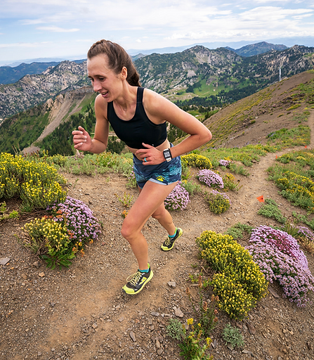 female runner running uphill through the mountains