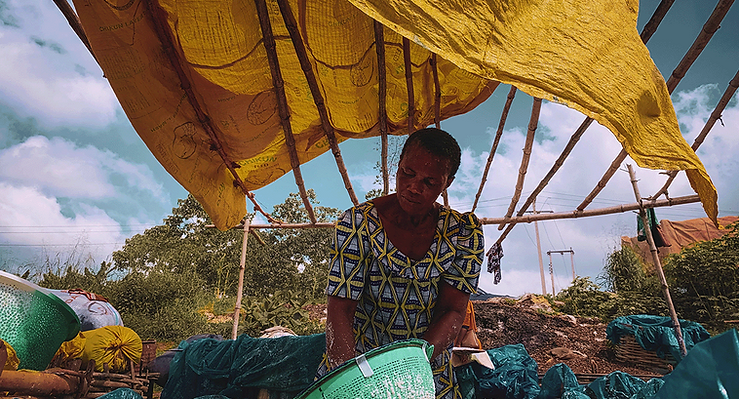 A women is running a business under a make shift tent.