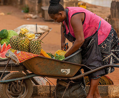 A womjen with a fruit selling business is preparing for the day.