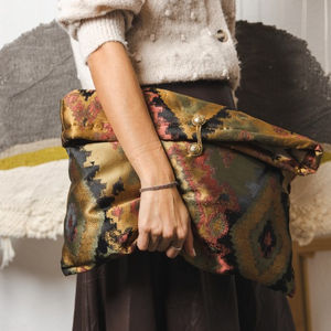Borsa artigianale fatta a mano con materiali naturali, caratterizzata da dettagli intrecciati e design unico.