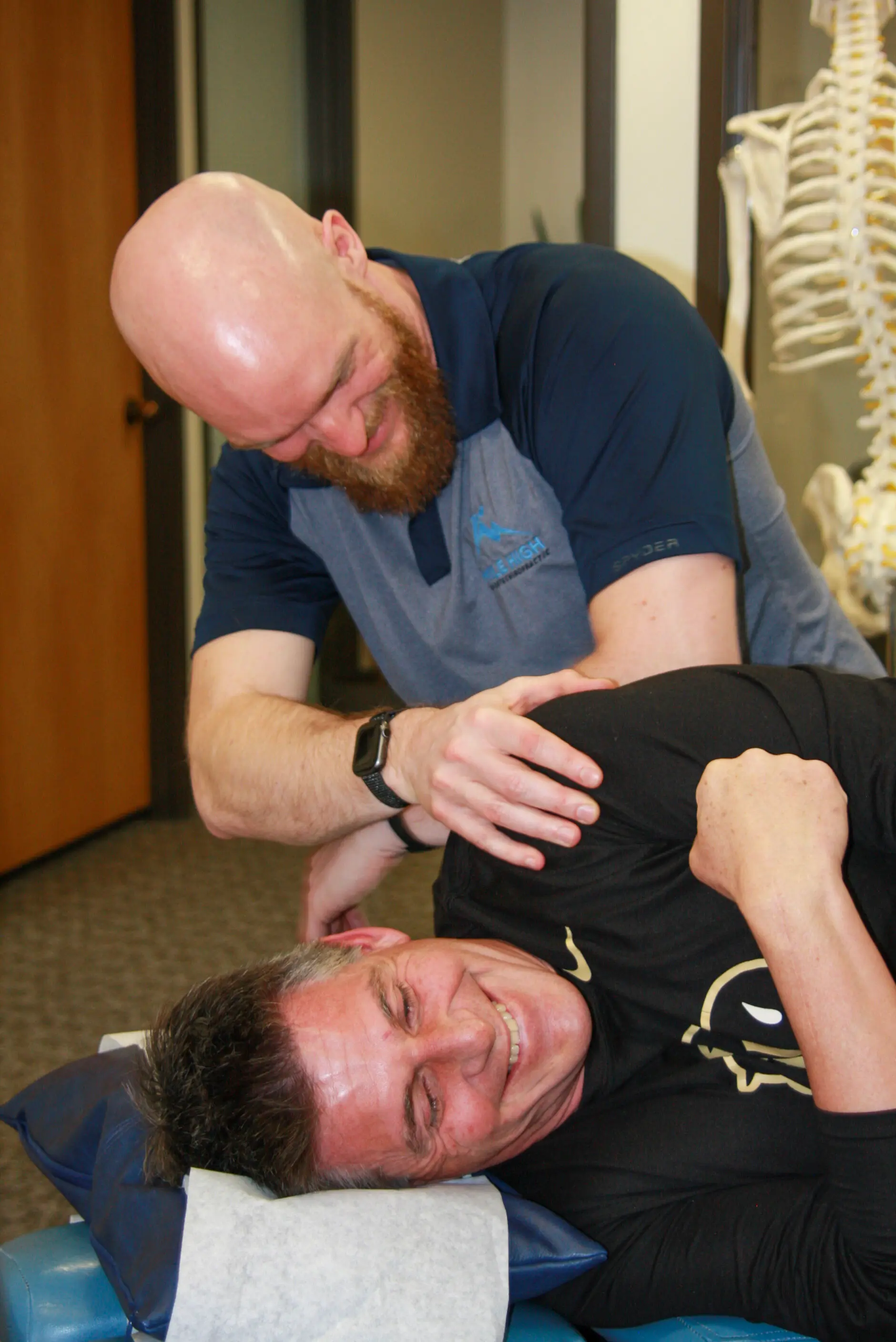Dr. Matt treating smiliing patient with elbow