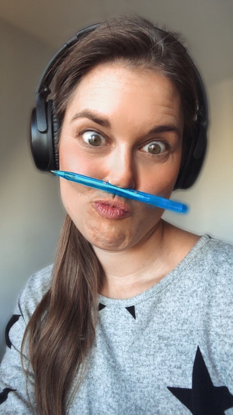 Selfie mit unter die Nase geklemmtem blauen Stift und Kopfhörern