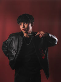 male model adjusts necklace in mobile studio setup
